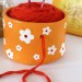 Small orange crochet yarn holder bowl with retro daisy flowers Knitter gifts