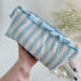 Large sky-blue striped cosmetic bag with ruffles