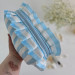 Medium sky-blue striped cosmetic bag with ruffles
