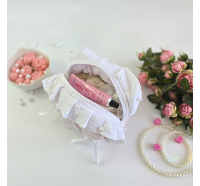 Small soft pink cosmetic bag with ruffles, bows and pearl-like beads