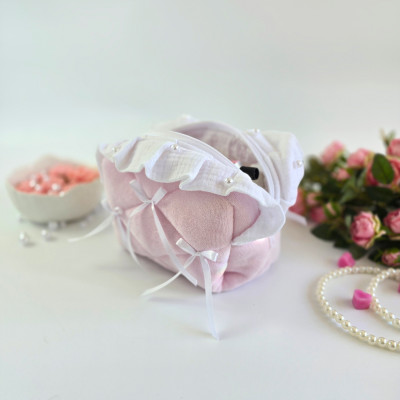 Small soft pink cosmetic bag with ruffles, bows and pearl-like beads