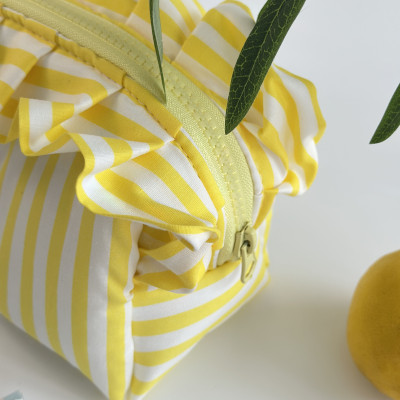 Small yellow striped cosmetic bag with ruffles
