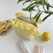 Small yellow striped cosmetic bag with ruffles